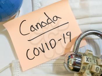 China virus Coronavirus COVID-19 infection Canada lock down COVID respiratory disease influenza effect on surgical mask and earth globe background