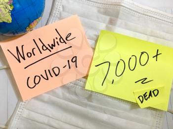 Coronavirus COVID-19 Worldwide infection medical cases and deaths. China COVID respiratory disease influenza virus statistics hand written on surgical mask and earth globe background