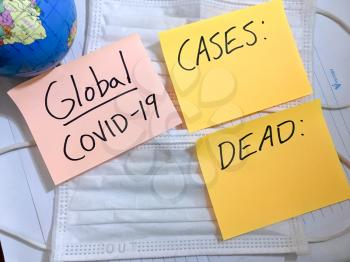 Coronavirus COVID-19 global infection medical cases and deaths. China COVID respiratory disease influenza virus statistics hand written on surgical mask and earth globe background