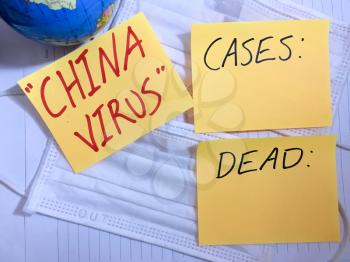 China virus Coronavirus COVID-19 infection medical cases and deaths. COVID respiratory disease influenza statistics hand written on surgical mask and earth globe background