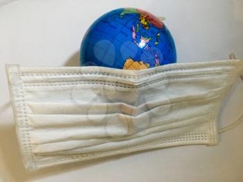 Earth globe wearing covered white surgical mask isolated disease concept pandemic coronavirus