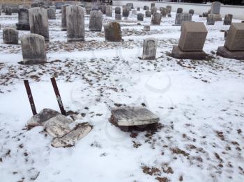 Broken headstone gravestone vandalized cemetey old graves wniter snow day