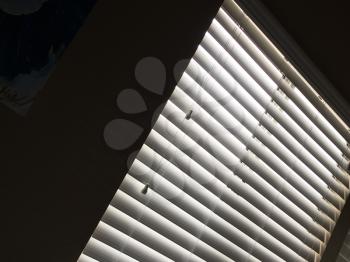 Horizontal blinds sunlight pattern window in dark room
