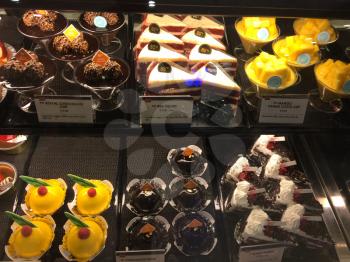 pastry sweets in bakery glass case brown chocolate and yellow