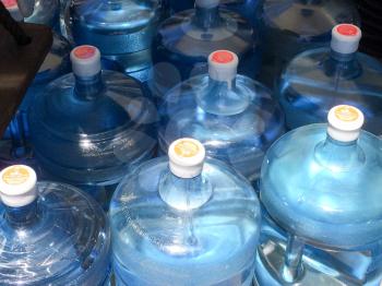 Five 5 gallon water bottles full and empty blue plastic dry and condensation droplets on USS Iowa naval warship destroyer battleship