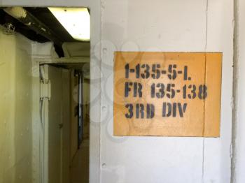 Military acronym text code stencil on wall yellow and white on USS Iowa naval warship destroyer battleship