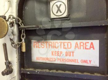 Restricted area keep out authorized personnel only red sign with padlock locked on USS Iowa naval warship destroyer battleship