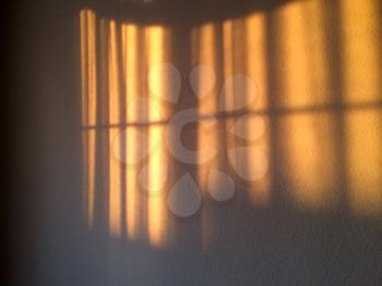 gold sunlight streams through curtains for golden design background on room wall