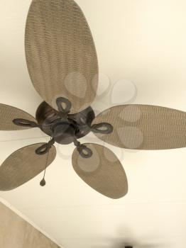 Ceiling fan on white background overhead with big leaf blades