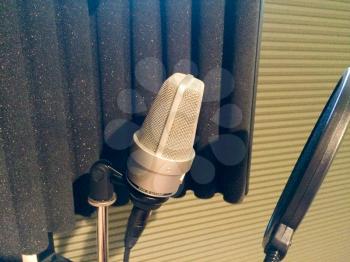 Professional microphone in music recording studio booth with pop wind filter