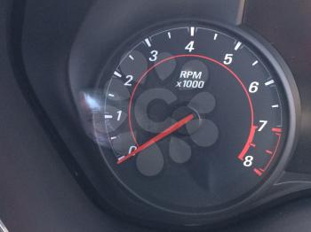 Tachometer in auto car dashboard camaro black dial with rpm numbers and red needle