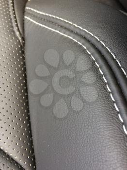 Black grey leather stitched seats in new luxury sports car close up detail thread