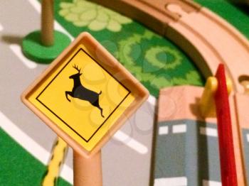 Deer crossing street sign in toy city play town in miniature size