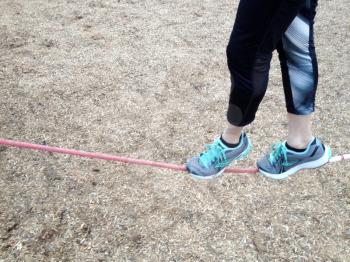 Tightrope slack line walker athletic sneakers at park balance