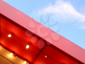Red canopy awning with yellow light bulbs abstract background with blue sky cloud