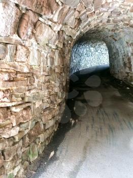 stone tunnelway walking path underground with light shining