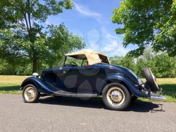 1934 Ford Roadster blue in park on green grass outdoor sky