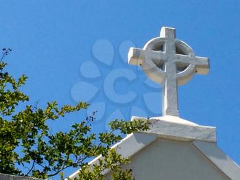 cross on top of presbyterian church with blue sky