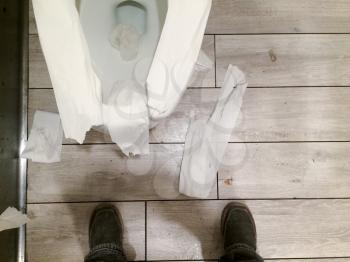 messy public restroom with toliet paper all over