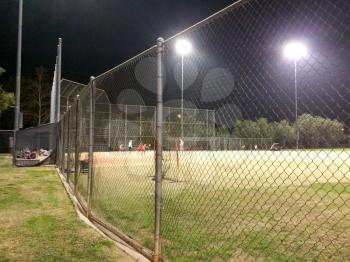 Night time baseball game at playing field outdoor with people and kids