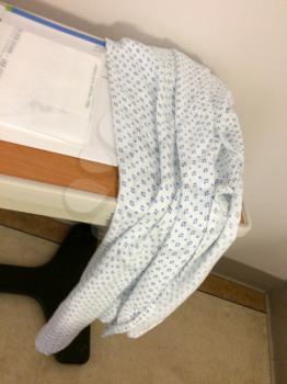used hospital gown on table for laundry pick up at discharge
