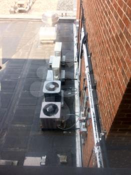 drab hospital patient window view looking at air conditioner units rooftop and brick wall