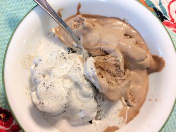 Chocolate and vanilla ice cream in bowl with oreos cookies and cream