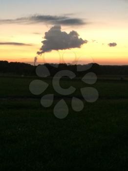 sunset and nuclear power plant cooling tower cloud of steam smoke