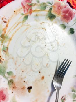 Empty dinner plate dirty with fork after yummy saisfying meal