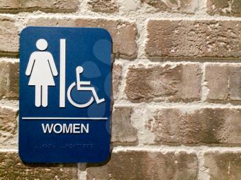 Women restroom blue white sign handicapped pictogram symbol on brick wall