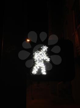 Crosswalk signal light man walking syymbol at night time