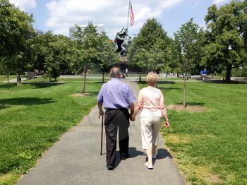 Senoir citizen couple holding hands walking at park for anniversary love