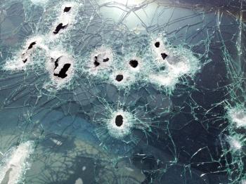 Automobile shot up bullet gun fire fight holes windshield broken glass