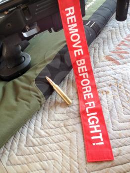 remove before flight red tag with rifle bullet brass