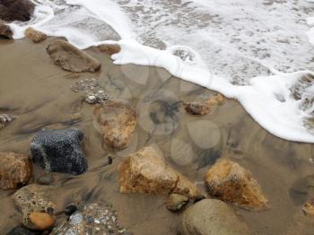 Beach surf coastline sand foam rocks stone