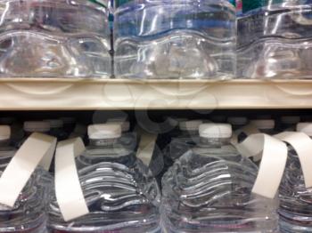 Large jug gallon plastic water bottles in cases with caps for sale supermarket shelf