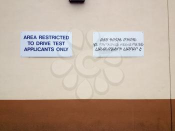Department of motor vehicles DMV motorcycle auto car driving test exam area sign with Armenian translation English