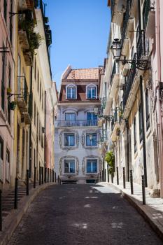 A street with a view of a house with azulejos in iconic Barrio Alto a night life neighbourhood of Lisbon during the day.