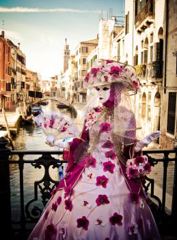 Masquerade in Venice, in rich exquisite costumes and masks, fan, hat with flowers, Italy, carnival