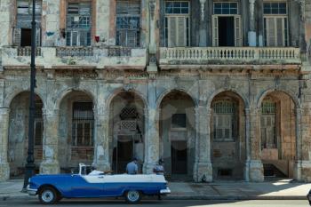 Havana, Cuba - 8 February 2015: Example of colonial architecture on Malecon with balconies and arches with vintage car paked in front