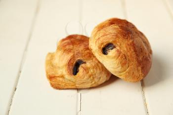 Two pain au chocolat, french pastry on white wooden background