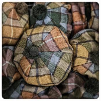 Yellow, orange and blue scottish tartan hats.  Processed to look like an aged, instant photo.
