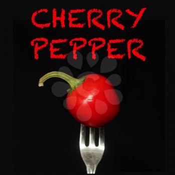 Cherry pepper on a fork on a black background