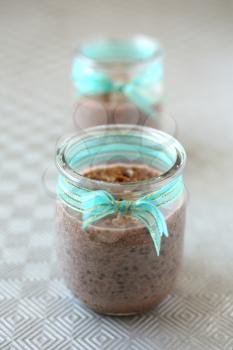 Healthy chocolate chia pudding with fresh nuts in a glass jar
