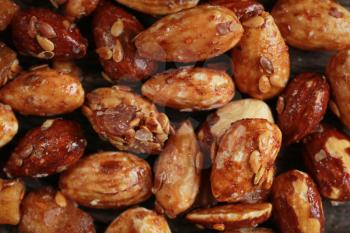 Close up of honey roasted almonds with sesame on a wooden table