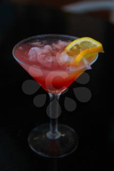 Cosmopolitan cocktail made with cranberry juice and vodka.  Decorate with lemon and a piece of orange