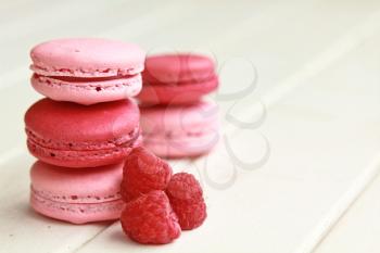 Raspberry macarons on a white table with fresh fruits 