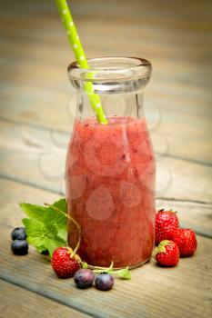 Berry smoothie with fresh fruits on a rustic wood