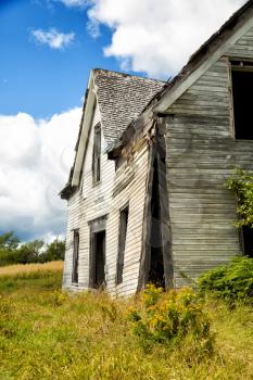 Side view of a derelict house in a middle of a field