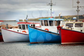 Blue, white and red fishing boats at the pier in Havre Aubert in Quebec, Canada